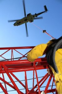 mann-gesichert-am-helikopter-montiert-einen-kran
